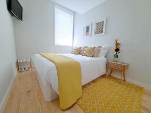 波尔图Boavista Luxury Villas的一间卧室配有一张带黄色毯子的大床