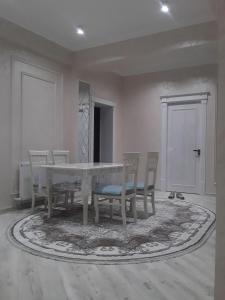 费尔干纳Apartment的一间配备有白色桌椅的用餐室