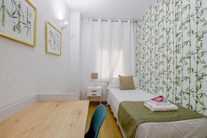 巴塞罗那阿尔卡姆金色公寓的一间小卧室,配有两张床和一张桌子
