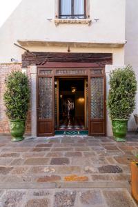 威尼斯Palazzo Keller的两株盆栽植物的建筑物入口