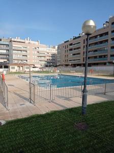 韦斯卡Acogedor apartamento con piscina y garaje的游泳池旁的街灯,游泳池旁有建筑
