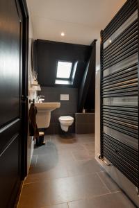 奥特马瑟姆B&B 'n Drost的一间带水槽和卫生间的浴室以及窗户。