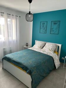 瓦隆蓬达克Vacances en Ardèche "maison pont d'arc"的一间卧室配有一张蓝色墙壁的床