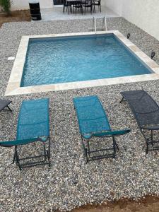 瓦隆蓬达克Vacances en Ardèche "maison pont d'arc"的两把椅子和一个配有两把椅子的游泳池