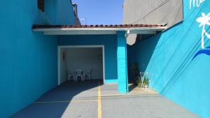 乌巴图巴Mar dos Sonhos Suítes的蓝色的建筑,设有蓝色的墙壁和庭院