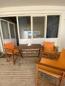 洛加拉斯Yellow Beach House的窗户客房内的一张木桌和椅子