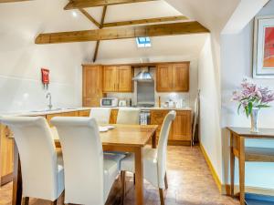 North ThoresbyThe Lodge - Uk44516的厨房配有木桌和白色椅子
