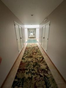 波萨达斯Hotel Maitei Posadas的地板上铺着地毯的空走廊