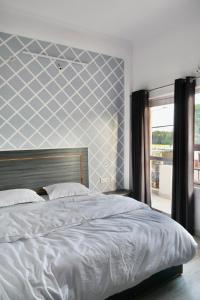 克久拉霍Aarambh Residency的一间卧室配有一张蓝色和白色墙壁的床