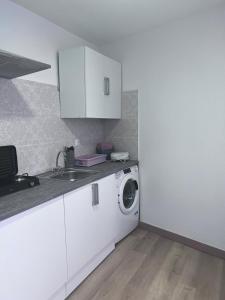 雷克纳Cantarranas的白色的厨房配有洗衣机和水槽