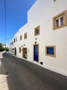 凯瑟拉Valente Rooms Kythira的白色的建筑,街道上设有蓝色的门