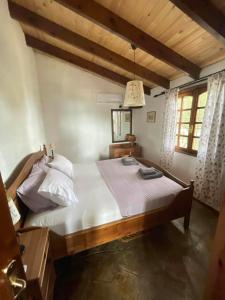 萨尔蒂villa athos的一间卧室配有一张带白色床单的大床