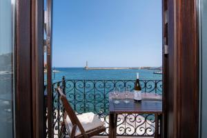 干尼亚Mosaic Venetian Harbour Suites的阳台上的桌子和一瓶葡萄酒