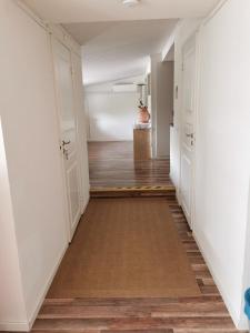 瓦尔贝里Tofta Konstgalleri-Hel Lägenhet 70kvm的空的走廊,有白色的墙壁和木地板