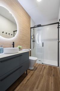 瓦伦西亚Marina Beach Apartments的一间带水槽、卫生间和淋浴的浴室