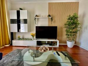 阿马多拉N3 Apartment的一间带电视和玻璃桌的客厅