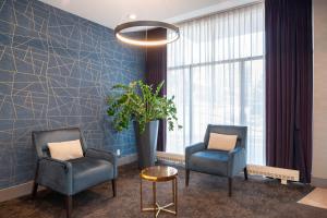 隆格伊蒙特利尔桑德曼酒店 - 隆格伊的一间设有两把椅子和盆栽的等候室