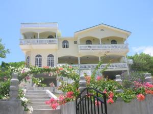Micoud扎马克住宿加早餐旅馆的一座黄色的大房子,有楼梯和鲜花