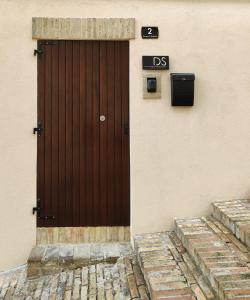 洛雷托Dolci Soggiorni的建筑物边的棕色门