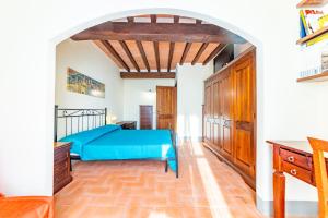 CollazzoneCasa Marlèn的一间卧室设有蓝色的床和拱门