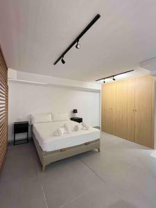 瓦伦西亚WeRentVLC - Espectacular Loft Duplex 1 hab的白色卧室设有一张大床和一个木制橱柜