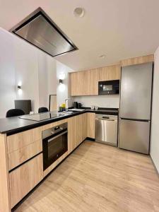 瓦伦西亚WeRentVLC - Espectacular Loft Duplex 1 hab的厨房配有木制橱柜和不锈钢用具