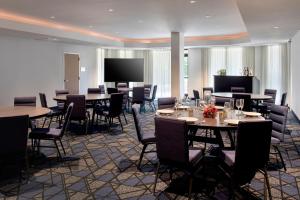普利茅斯会议费城普利茅斯米庭万怡酒店的用餐室配有桌椅和投影屏幕