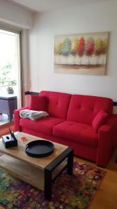 埃佩尔奈L'épopée de l'Avenue - Parking - Avenue de Champagne - Epernay的客厅里一张红色的沙发,配有茶几