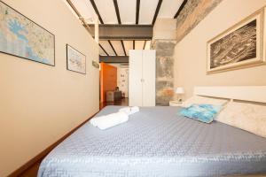 热那亚Loft Galata的一间卧室配有一张床,上面有两条毛巾