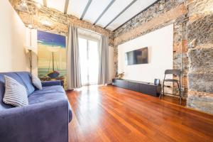 热那亚Loft Galata的客厅设有蓝色的沙发和砖墙