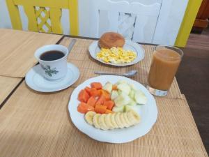 基多加拉帕戈斯自然生活旅舍的一张桌子,上面放着两盘水果和一杯咖啡