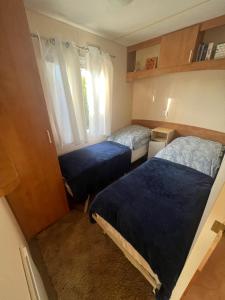 梅尔诺Mandala Mielno Camping的小房间设有两张床和窗户