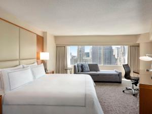 芝加哥Swissotel Chicago的大型酒店客房设有一张大床和一张沙发。