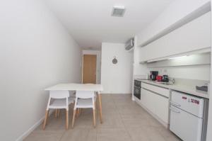 布宜诺斯艾利斯Libertador Complete Suite的厨房配有白色桌子和白色家电