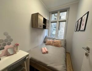 格但斯克MMRent Rose Room的一间小卧室,配有一张带两个粉红色拖鞋的床