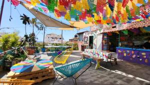 巴亚尔塔港Hostel Vallarta的一个带椅子和遮阳伞的庭院以及一间商店