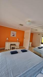 WaikerieSpacious Holiday Home - Waikerie的一间卧室设有两张床和橙色的墙壁