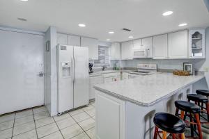费南迪纳比奇Striking Oceanview Condo的厨房配有白色橱柜和白色冰箱。