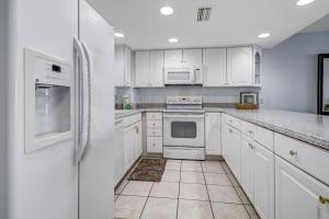 费南迪纳比奇Striking Oceanview Condo的白色的厨房配有白色家电和白色橱柜
