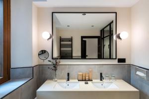 罗德里戈城罗德里戈城市旅馆的一间带两个盥洗盆和大镜子的浴室