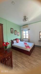 琅勃拉邦Villa Thavisouk Legend - Luang Prabang的一间卧室配有一张大床和一张桌子
