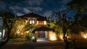 库塔KUTA - 4BR Villa with Private XL Pool的夜晚的房子,前面有灯