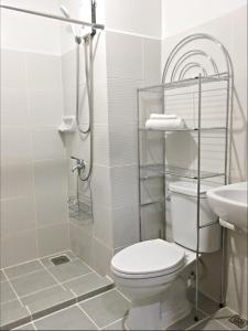 巴科洛德MesaVirre Garden Residences Unit 402的白色的浴室设有卫生间和水槽。