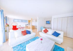 宫古岛ヴィラアマルフィ パームスプリングス宮古島リゾート的客厅配有2张白色沙发和1张桌子