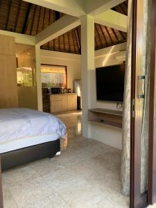 瑟克通Seaside Villa Kecil的一间卧室配有一张床和一台平面电视