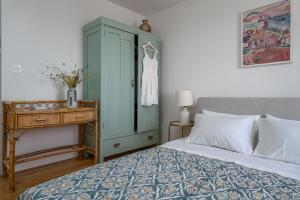 波尔Nona Vi - Boutique Stone House的一间卧室配有蓝色橱柜和一张带桌子的床