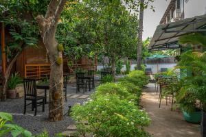 暹粒Habana Angkor Boutique Hotel的庭院配有桌椅和树木