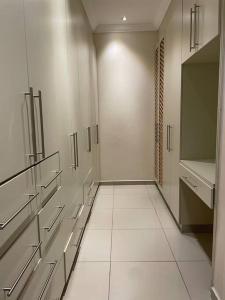 姆巴巴内Sermj Abode Nkoyoyo的浴室拥有白色的墙壁和白色的瓷砖地板。