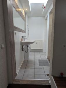 WeimarFerienwohnung/Monteurwohnung Altes Café的一间带水槽和瓷砖走廊的浴室