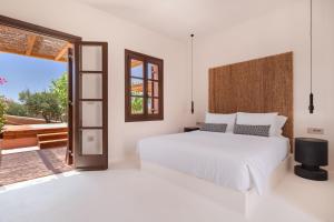 纳克索乔拉Akre Hotel的卧室设有白色的床和大窗户
